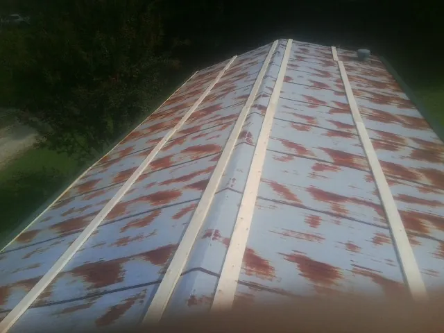 Rusted metal roof panels with new wood purlins before replacement — Storm Damage Roof Repair in Moravia by Roofing Brothers