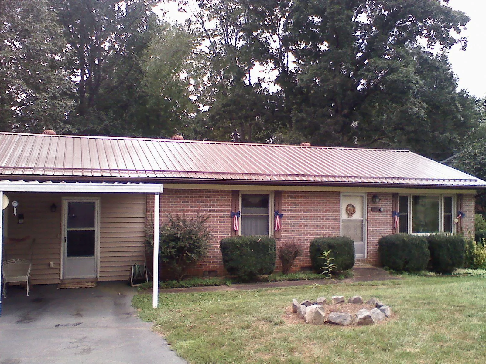 Bronze metal roof and carport on a brick ranch home — Roof Repair work by our crew in Moravia
